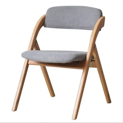 Chaise à manger pliable avec des jambes en bois massif et un design moderne en tissu ou en cuir PU