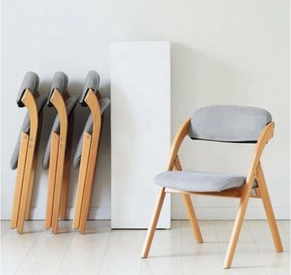 Chaise à manger pliable avec des jambes en bois massif et un design moderne en tissu ou en cuir PU