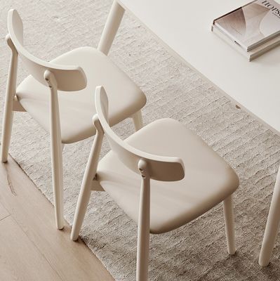 Chaise de salle à manger de style nordique avec des jambes en bois massif et un revêtement en tissu en finition nitrolacque